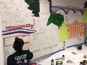 Student Taylor Springer works on mural in Cycle Studio