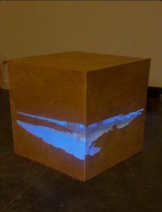 An example of Youngborg's artwork. She built a few wooden cubes, traced coastlines of some of the places she has lived, and projected her video memories into these bodies of water.