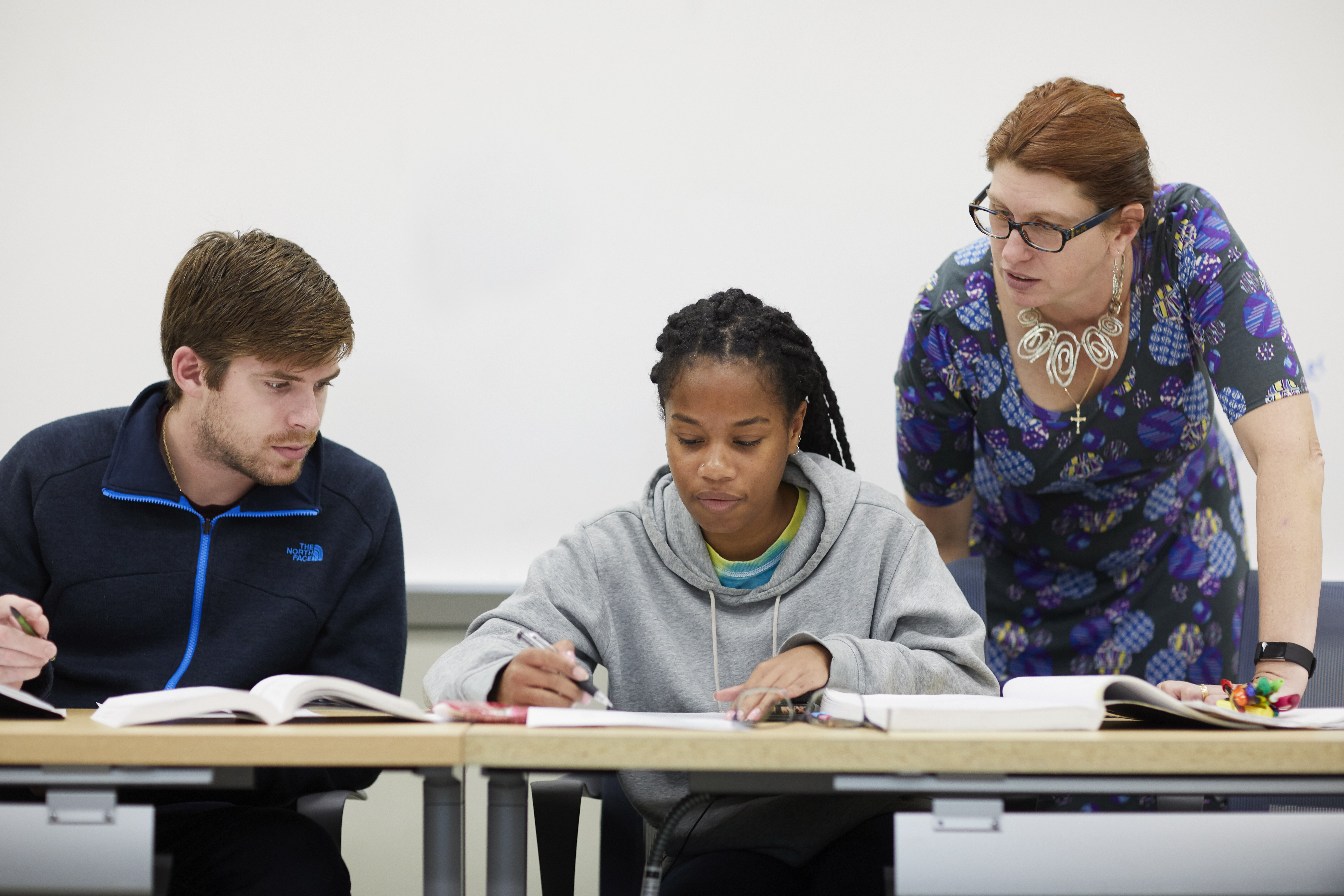 Chemistry Physics Chair and Professor Janet Asper works with several students.