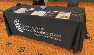 College of Education table with brochures, pens and other materials.