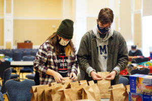 Chenin Guber (left) and AJ Gluchowski make bagged lunches for Micah Hospitality Center as part of Saturday’s MLK Day of Service. Photo by Suzanne Carr Rossi.