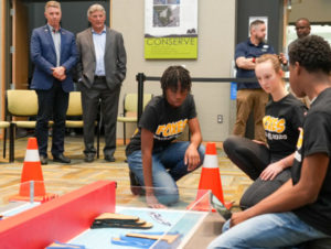 From left, U.S. Rep. Rob Wittman, R-Virginia, and University of Mary Washington’s John Burrow watch as King George high-schoolers Samantha Jones, Susan Randall and Ashton Jones compete in the Innovation Challenge @Dahlgren. Back right are UMW Assistant Professor of Special Education Kevin Good and Dahlgren Campus Director Michael Hubbard. (U.S. Navy photo/Released)