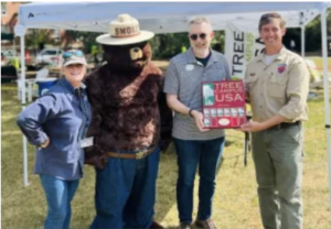 Smokey made an appearance at the recent Tree Festival, with (from left) Director of Landscape and Grounds Holly Chichester, Chief of Staff Jeffrey McClurken, and Scott Adams of the Virginia Department of Forestry.