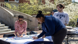 Newly elected SGA President Jaylyn Long (front) signs the Accountability banner during ASPIRE Week. With her are Martina Pugh and Joey Zeldin. ASPIRE Week celebrates UMW Eagles' core values.