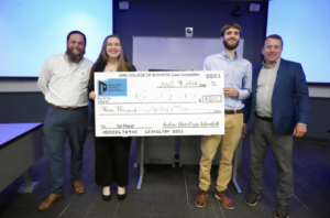 From left to right: Craig Schneibolk, UMW students Jenna Diehl and Brian Gaydos, and Andrew Blate &rsquo;04 pose with the winning check at the end of last week&rsquo;s Case Competition for business students. Diehl and Gaydos won the competition, judged by Schneibolk and Blate, who sponsor it, along with two other UMW alumni. Photo by Suzanne Carr Rossi.