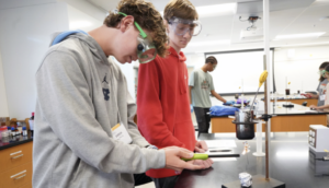 Fredericksburg Academy sophomore Enoch Huffman partnered up with Towson High School junior Liam Hill to investigate the energy in biopolymers in carbohydrates and proteins by setting food on fire. The session, ‘Polymers, Plastics and Me,’ was one of several providing hands-on learning opportunities to high-schoolers during UMW’s Summer Enrichment Program. Photo by Suzanne Carr Rossi.