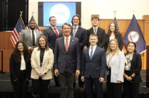 UMW alumna Kristen Ramey &rsquo;17 (front row, second from left) poses for a photo with Gov. Glenn Youngkin and other Virginia Management Fellows. As a member of VMF&rsquo;s sixth cohort, Ramey is putting the business and public policy background she gained from Mary Washington to work as she explores careers in state public service. Photo courtesy of Kristen Ramey.