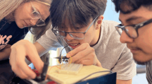 Hannah Steele &rsquo;26, a UMW student mentor and Noyce Scholarship recipient, guides high schoolers Vincent Phan (left) and Alexander Rosas in creating a circuit. Photo by Katie Van Houten &rsquo;27.