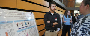 UMW junior Mohammad Ali Hassan explains his work investigating the effects of immunogenic chemotherapy on triple-negative breast cancer during the sixth annual Network for Undergraduate Research in Virginia Conference. Hosted by the University of Mary Washington on Saturday, Nov.1, the daylong event welcomed student researchers from across the Commonwealth. Photo by Suzanne Carr Rossi.