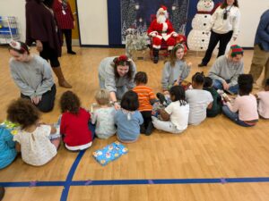 Students hand out gift boxes to area preschool students.