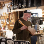 photo of a man named Larry Kinkle holding an instrument made of wood
