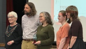 Photo of a group of people (Angie Kemp and her team) accepting an award