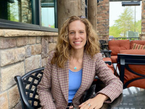 Photo of a woman sitting in a chair with blaze who is Associate Professor Jennifer Hansen-Glucklich in the Department of Modern Languages and Literatures