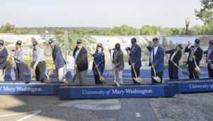 Several people hold shovels at the groundbreaking event