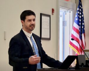 Photo of a man in a business suit at a podium speaking