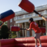 Students dressed in red and green play inside a bouncy ring during a playful competition on Devil-Goat Day