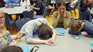 students playing bingo at tables in a conference room on campus