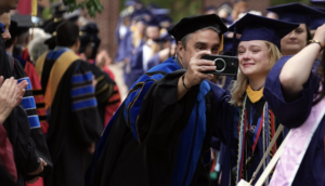 A graduate and faculty member take a picture together on campus walk