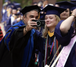 A graduate and faculty member take a picture together on campus walk