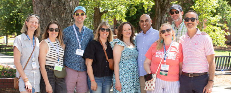 A group of alumni stand together on Campus Walk