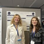 Two students, mathematics majors Juniper Creskoff and Ashton Crawford, stand in front of a academic poster