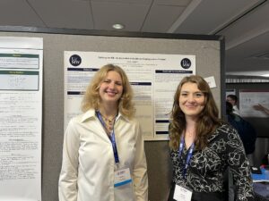Two students, mathematics majors Juniper Creskoff and Ashton Crawford, stand in front of a academic poster