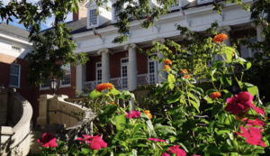 UMW's Lee Hall building on campus with flowers and foliage in the foreground