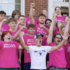 large group of students in mostly pink t-shirts on the steps of a campus building