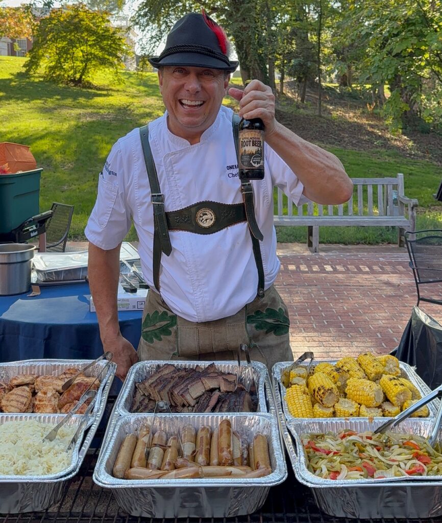 Man in Alpine hat and lederhosen serving German food