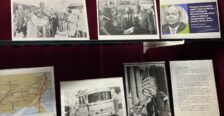 Display of memorabilia on glass shelf inside a display case with red velvet backing