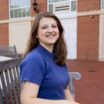 woman sits outdoors on a bench