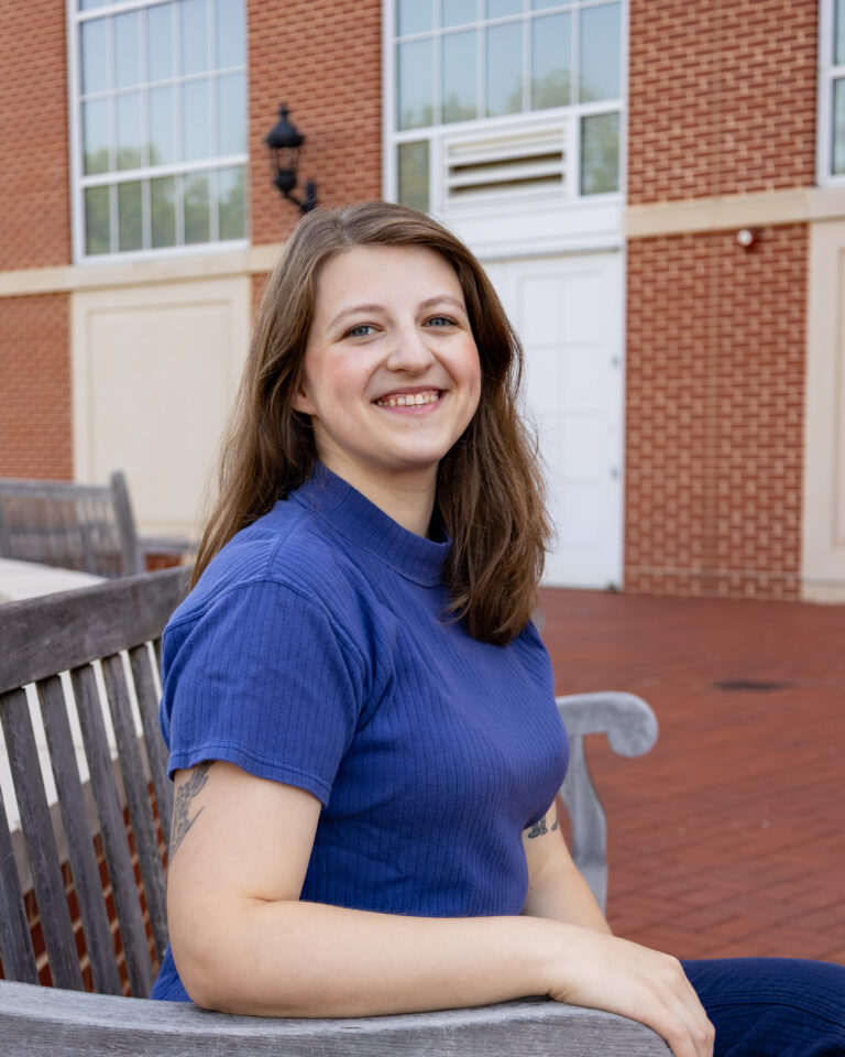 woman sits outdoors on a bench